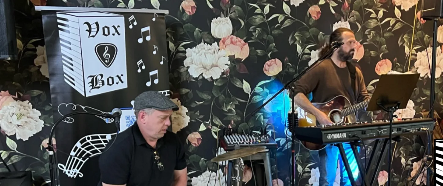 Vox & Box Duo performing live with guitar, keys, and percussion